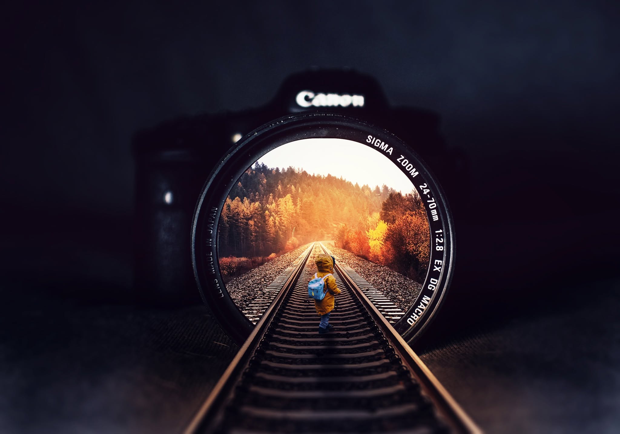 Photo composite: an autumn railway scene viewed through a Canon camera lens